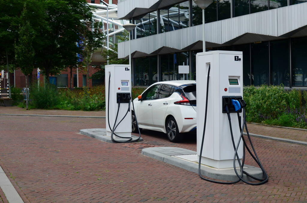 Charging modern electric car from station outdoors